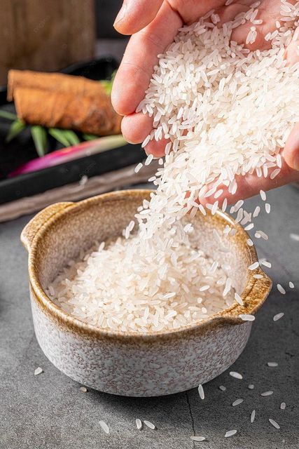White Rice Grains in Wooden Spoon for Cooking and Baking - Image 1